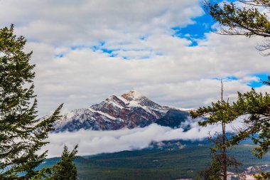 Rocky Dağları, Kanada. Piramit Dağı güneşte parlar. Sabah sisi güzel bir şekilde gökyüzüne yükseliyor. Ekolojik ve fotoğraf turizmi kavramı