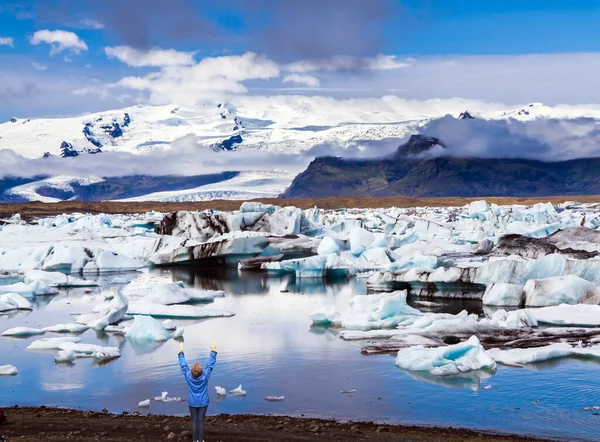 在泻湖上热情的女游客 白色和蓝色的冰山和浮冰反映在水面上 极端旅游 北方旅游和摄影旅游的概念 — 图库照片