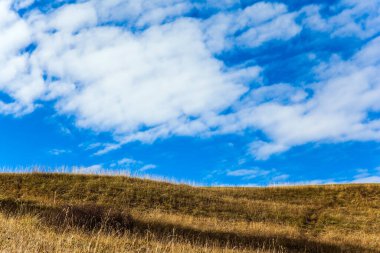 Kuru çimenler ve bulutlu gökyüzü. Sonbaharın başlarında Tyrol tepeleri. Alpe di Siusi, İtalya 'nın Dolomitler şehrinde büyüleyici bir platodur. Hint yazı. Yürüme, ekolojik ve fotoğraf turizmi kavramı