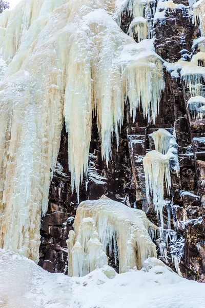 冬天的故事 冰冻瀑布的冰流从森林的陡峭处滑落下来 拉普兰的圣诞节芬兰的新年 积极旅游 摄影和生态旅游的概念 — 图库照片