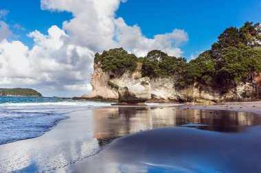  Islak kumdaki bulutların ayna yansımaları. Katedral Koyu 'nda okyanus gelgiti. Yeni Zelanda 'ya git. Egzotik, ekolojik ve fotoğraf turizmi kavramı
