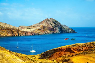 Madeira Atlantik 'teki bir adadır. Madeira adasının batı kıyısı - yatları ve tekneleri olan kayaların arasındaki körfez. Kör edici gün ortası güneşi. Aktif, ekolojik ve fotoğraf turizmi kavramı
