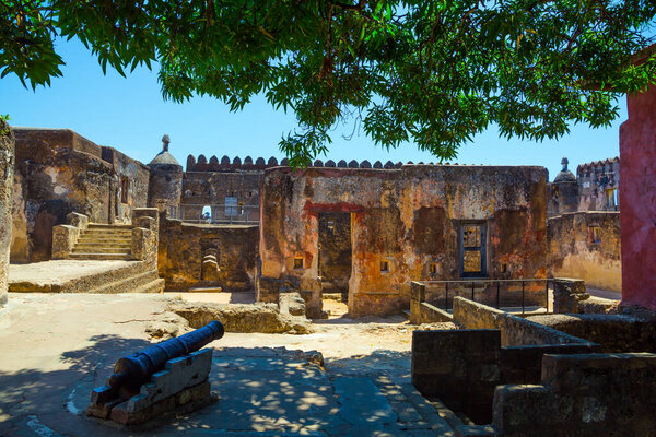 Guns are on display in the fortress. Fort Jesus -  medieval fortification in Mombasa, Kenya. Bastion and loopholes in the thick ancient walls. The concept of historical, educational and photo tourism