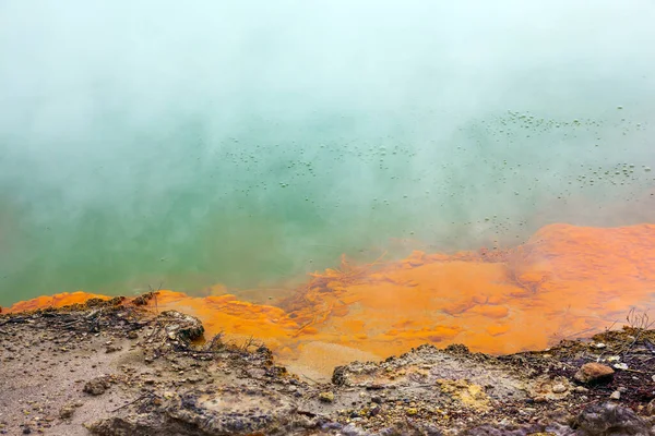 Orange shores of a hot lake with gas bubbles. Thermal Wonderland Champagne. Wai-O-Tapu, New Zealand. The geothermal zone of Rotorua. The concept of exotic, ecological and photo tourism