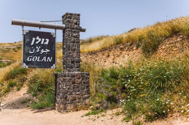 Dikilitaş işareti, Golan Tepeleri. Tatil günü. İsrail 'de Hamursuz Bayramı. Golan Tepeleri 'nin çiçekli yeşil yamaçları.