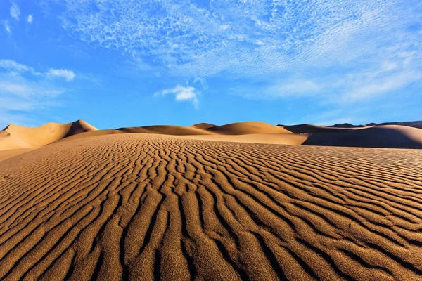 Kumsalda sihirli ışık oyunu. Kum tepeleri turuncu gündoğumuyla aydınlanıyor. ABD. Mesquite Düz Kum tepeleri Kaliforniya 'daki Ölüm Vadisi' nin bir parçasıdır. Aktif, ekolojik ve fotoğraf turizmi kavramı