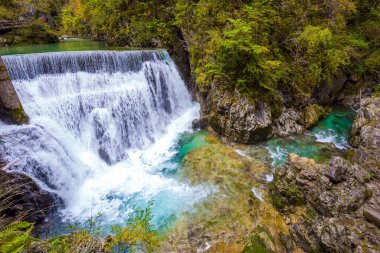 Aktif ve fotoğraf turizmi kavramı. Slovenya. Vintgar dağ geçidi üzerindeki resim gibi eski bir köprü. Dağ nehrinde güçlü bir şelale.