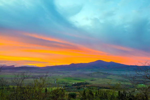 The sun rises. Incredible clouds at sunrise. The edge of the sky turns pink. Valley photographed from a protective wall around the city of Pienza. The concept of active and photo tourism