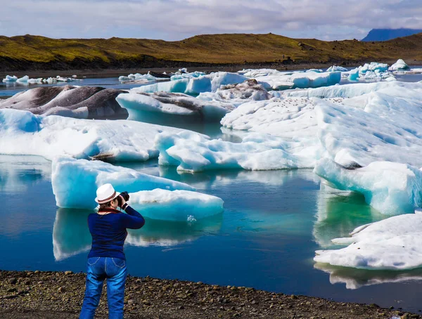 ジーンズの女性は壮大な風景を撮影します アイスランド 白と青の氷山と氷の洪水は ラグーンJokulsaurlounに反映されます 北部と写真観光の概念 — ストック写真