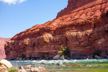 Fırtınalı geniş nehir, akıntılar, dikenli kızıl kumtaşı kıyıları ve soğuk su. Lee 'nin Feribotu, Colorado Nehri' ni geçen tarihi bir feribot. Arizona mı? Ekstrem ve fotoğraf turizmi kavramı