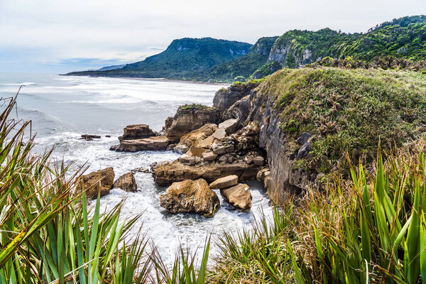 Живописное побережье, мощный прибой, огромные камни и скалы. Блинная скала является природным чудом национального парка Папароа. Новая Зеландия, Южный остров. Концепция экологического, активного и фототуризма 