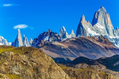 Resimli dağ sırası, öğlen güneşiyle aydınlatılıyor. Fitzroi - Patagonya 'da Arjantin ve Şili arasındaki sınır bölgesinde bir dağ zirvesi. Ekstrem, aktif ve fotoğraf turizmi kavramı