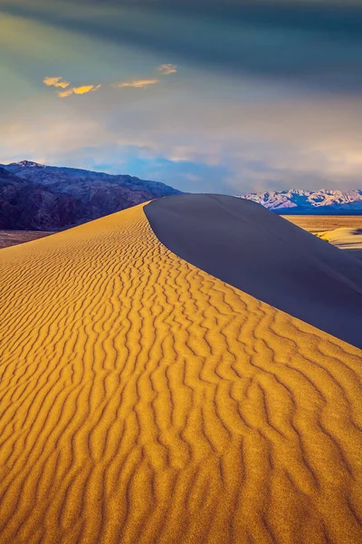Magical desert morning. Mesquite Flat Sand Dunes - dunes in Death Valley. USA. The sand lies in light waves. The dunes are located along Road 190. The concept of active and photo tourism