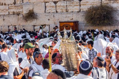 JERUSALEM, ISRAEL - 26 Eylül 2018: Sukkot. Dindar Yahudiler kutsal Tevrat Parşömenleri taşırlar. Binlerce Yahudi tallitlere sarılıp Batı Duvarı 'nda dua ediyor. Dini turizm konsepti. 