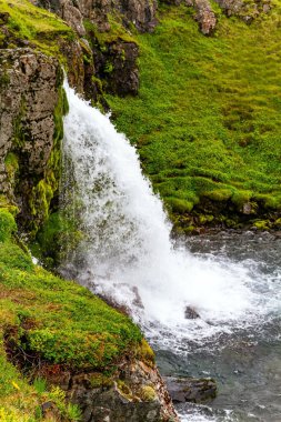 Şelaleler ve yeşil çimenler. Soğuk yaz. Grundarfjord kıyısındaki Kirkjufell Dağı 'nın etrafını sardı. İzlanda 'nın resimli manzarası. 