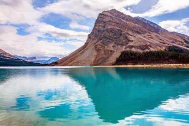 Zirvedeki kayalıklar pürüzsüz suya yansıyor. Alberta. Turkuaz soğuk suyla görselleştirilmiş buzul yay gölü. Banff Ulusal Parkı. Kanada 'nın Rocky Dağları. 