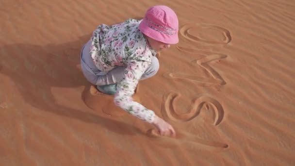 Teenager ragazza dipinge sulla sabbia in Rub al Khali deserto magazzino filmati video — Video Stock