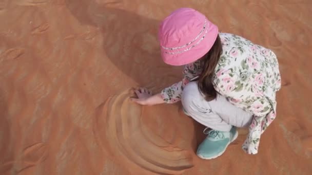 Teenager girl paints on the sand in Rub al Khali desert stock footage video — Stock Video