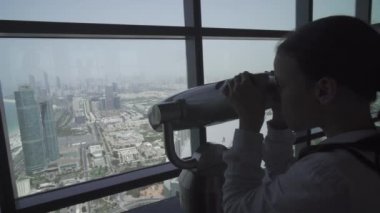 Genç kız Abu Dabi teleskopla gözlem güverte stok görüntüleri video görünüyor.