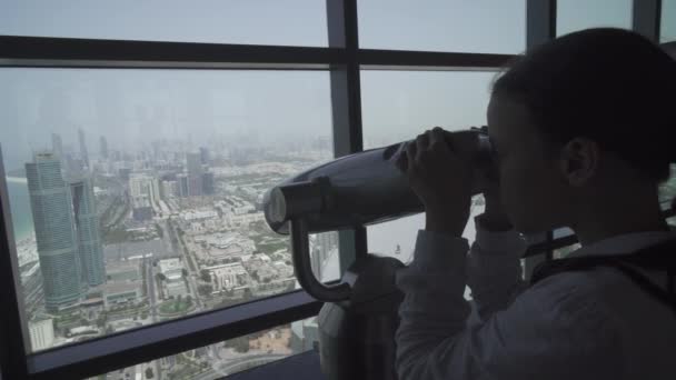 Tienermeisje kijkt door de Abu Dhabi telescoop vanaf de observatie dek stock footage video — Stockvideo