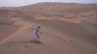 Genç kız sandboard Rub al hali çöl Birleşik Arap Emirlikleri Stok görüntüleri bir kumul yamacında video rulo
