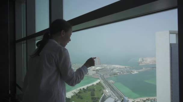 Tonårig flicka ser genom teleskopet Abu Dhabi från observation däck arkivfilmer video — Stockvideo