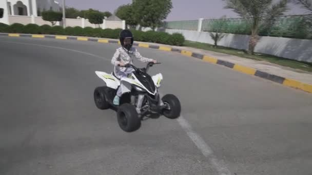 Девушка-подросток едет на квадроцикле по дороге — стоковое видео