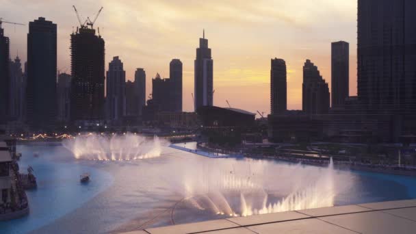 Dubai Fountain es el sistema de fuentes coreografiado más grande del mundo en el fondo del atardecer en el video de imágenes de Burj Khalifa Lake — Vídeos de Stock