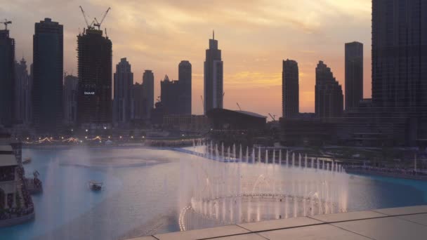 Dubai Fountain is de werelden grootste gechoreografeerd fontein systeem op zonsondergang achtergrond stock footage video — Stockvideo