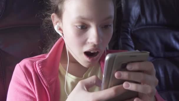 Cheerful teenage girl plays a game on smartphone in the cabin of the plane while traveling stock footage video — Stock Video