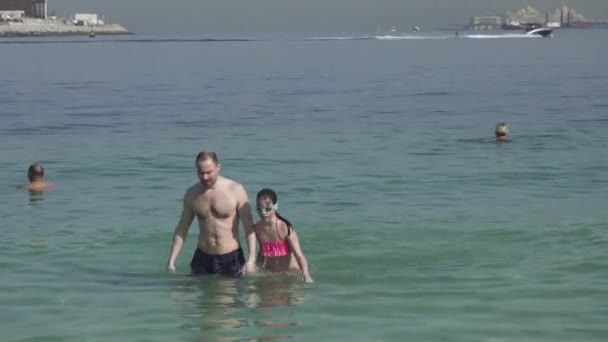 Toeristen zijn zwemmen in helder water op Marina beach in Dubai stock footage video — Stockvideo