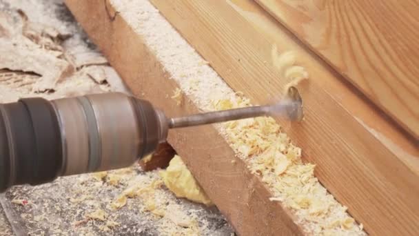 Electric drill with a nozzle makes a hole in wooden wall stock footage video — Stock Video