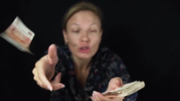 Mujer sorprendida lanza billetes de cinco mil rublos sobre fondo negro, feliz gran pila de dinero en cámara lenta archivo de vídeo — Vídeo de stock