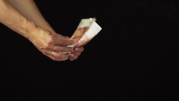 La mano femenina dispersa cinco mil rublos de billetes en el fondo negro de cámara lenta de archivo de vídeo — Vídeo de stock