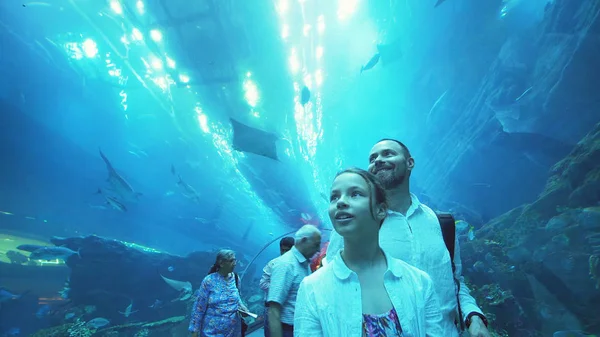 Dospívající dívka s tátou obdivovat podmořský život v tunelu skleněné akvárium v Dubai Mall — Stock fotografie