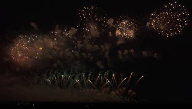 Kara gökyüzü arka planında renkli havai fişekler