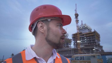 Bir kask, mimar, mühendis, inşaat akşam ilerlemesini Yöneticisi anlatıyor adam