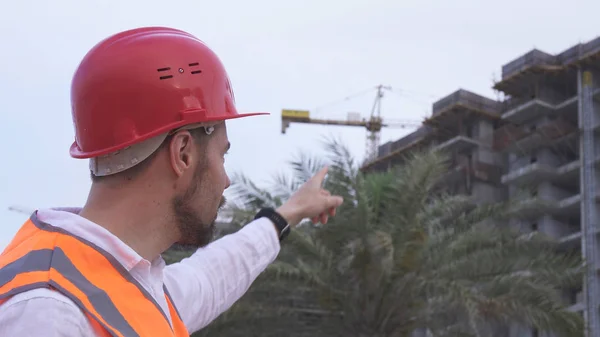 Mann mit Helm, Architekt, Ingenieur, Manager erzählt abends vom Baufortschritt — Stockfoto
