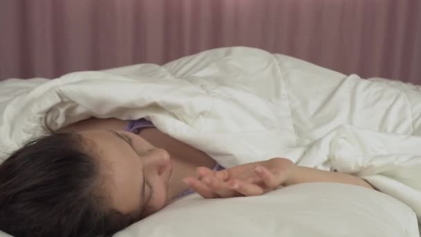 Mooie tiener meisje wakker in bed en glimlacht stock footage video — Stockvideo