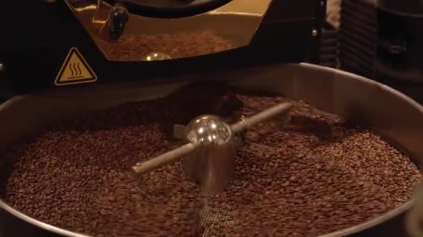 Granos de café oscuros y aromáticos en la máquina de tostado moderna material de archivo de vídeo — Vídeo de stock