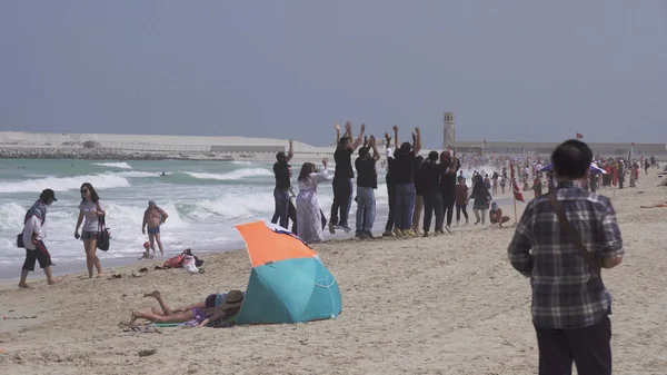 在迪拜朱美拉公共开放海滩上, 游客在波斯湾的背景上被拍到 — 图库照片