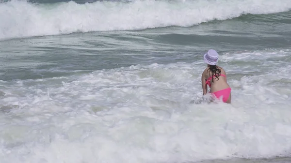 Tienermeisje in een badpak gelukkig springt in golven van de Perzische Golf op het strand van Dubai — Stockfoto