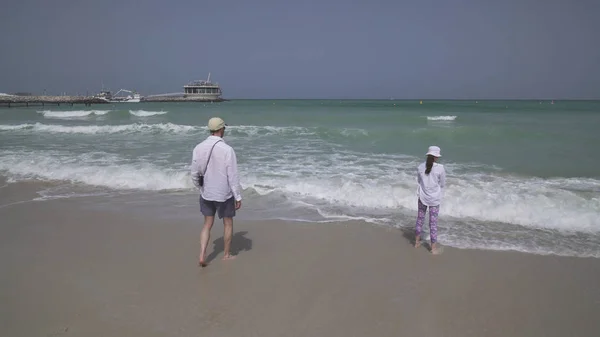 Flicka Tonåring med pappa gå in havet vågor av Persiska viken på stranden i Dubai — Stockfoto