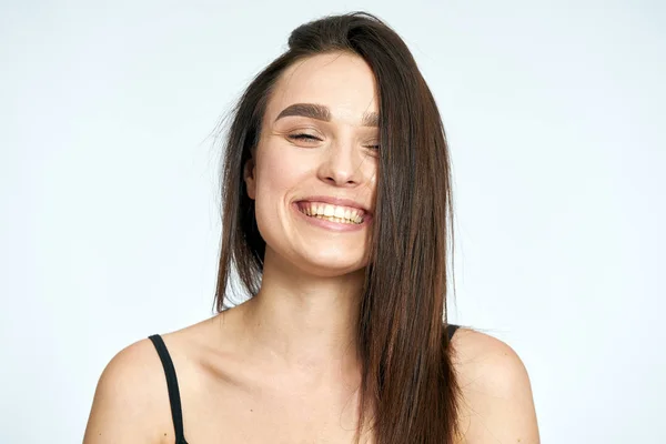Mooi jong meisje glimlacht op een lichte achtergrond — Stockfoto