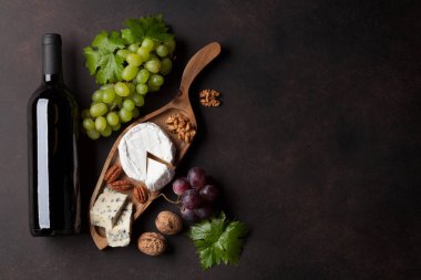 Şarap şişesi, üzüm, fındık ve peynir tabağı. Metin alanı olan üstten görünüm