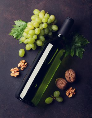 Şarap şişesi, üzüm ve fındık. Üstten görünüm. Tonda