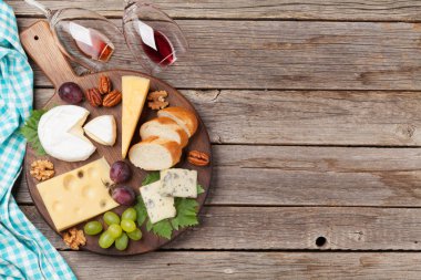 Peynir kurulu üzüm ve fındık ahşap arka plan ile. Metin alanı olan üstten görünüm