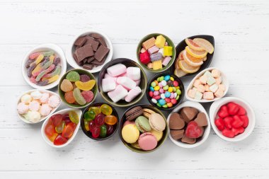 Colorful sweets. Lollipops, macaroons, marshmallow, marmalade and candies. Top view clipart