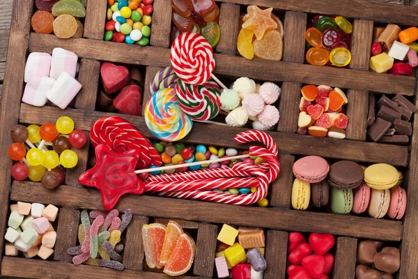 Colorful sweets box. Lollipops, macaroons, marshmallow, marmalade and candies. Top view
