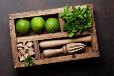 Mojito kokteyl malzemeler ve bar aksesuarları kutusu ahşap masa üzerinde. Üstten görünüm